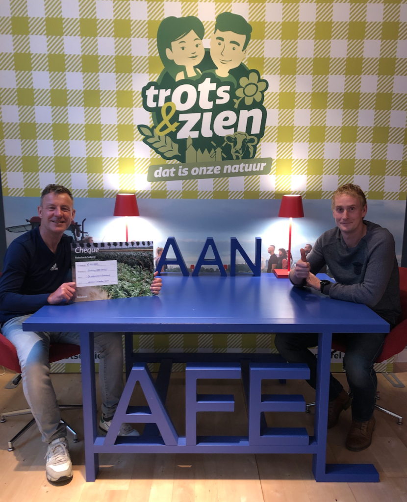 Wim Groot Koerkamp toont trots de cheque die Stichting AAN TAFEL! uit handen van Bas Booijink namens Rabobank Salland mocht ontvangen. 